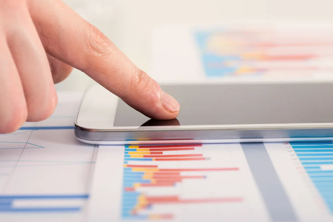Hands using a smartphone to check data and graphs