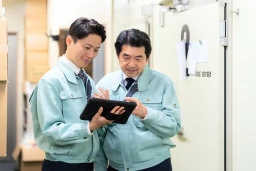 Junior and experienced staff checking work procedures on a tablet